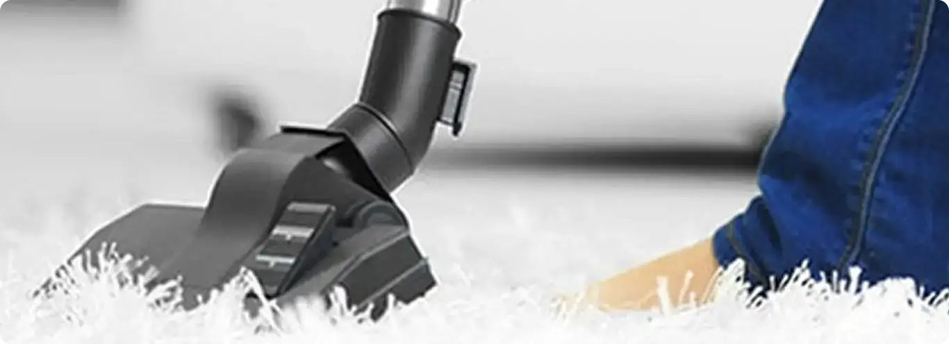 Close-up of a professional vacuuming a white carpet in Port Reading.